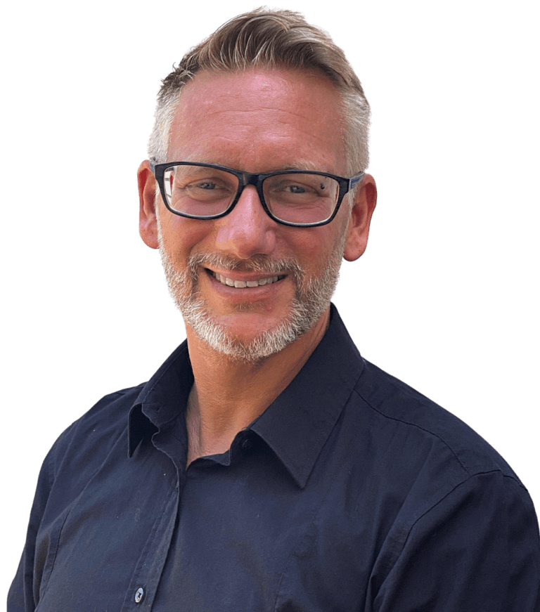Ein Mann mit kurzen, hellbraunen Haaren, Brille und gestutztem Bart lächelt, während er ein dunkles Button-up-Hemd trägt und bereit ist, Ihnen beim WordPress reparieren zu helfen. Er steht vor einem schlichten weißen Hintergrund.